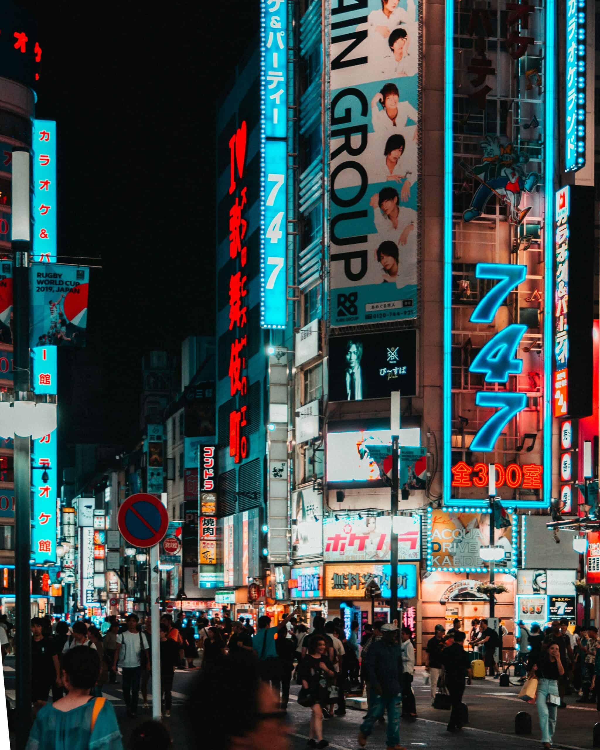Vibrant nighttime city street in Seoul with neon signs and busy pedestrians; iconic Korea entertainment and shopping district.