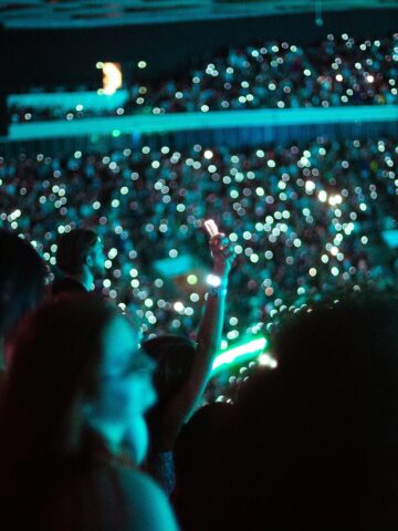 Vibrant night concert audience with glowing lights and smartphones in Seoul, Korea.