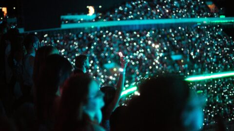 Vibrant night concert audience with glowing lights and smartphones in Seoul, Korea.