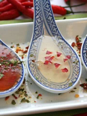 A tray of different Asian sauces on spoons.