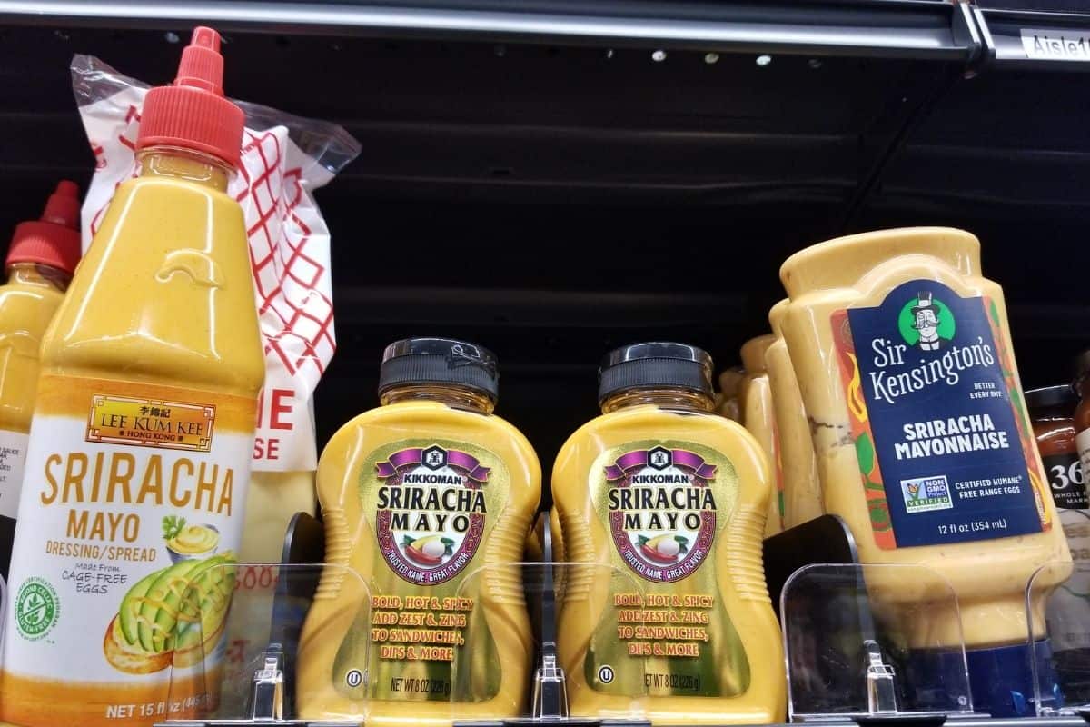 Various store-bought sriracha mayo in a grocery shelf.