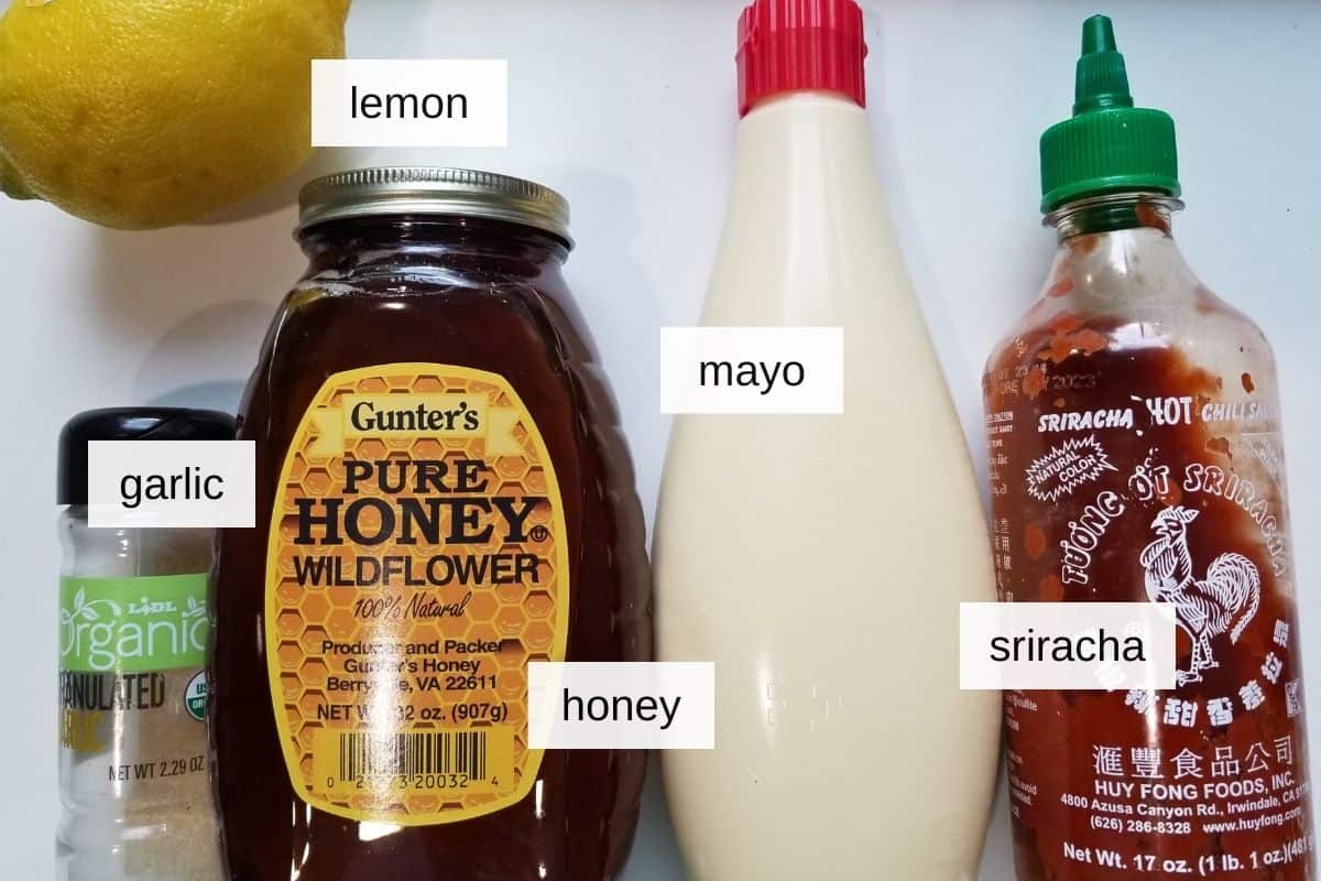 Ingredients for sriracha mayo, including lemon juice, mayonnaise, garlic powder, honey, and sriracha.