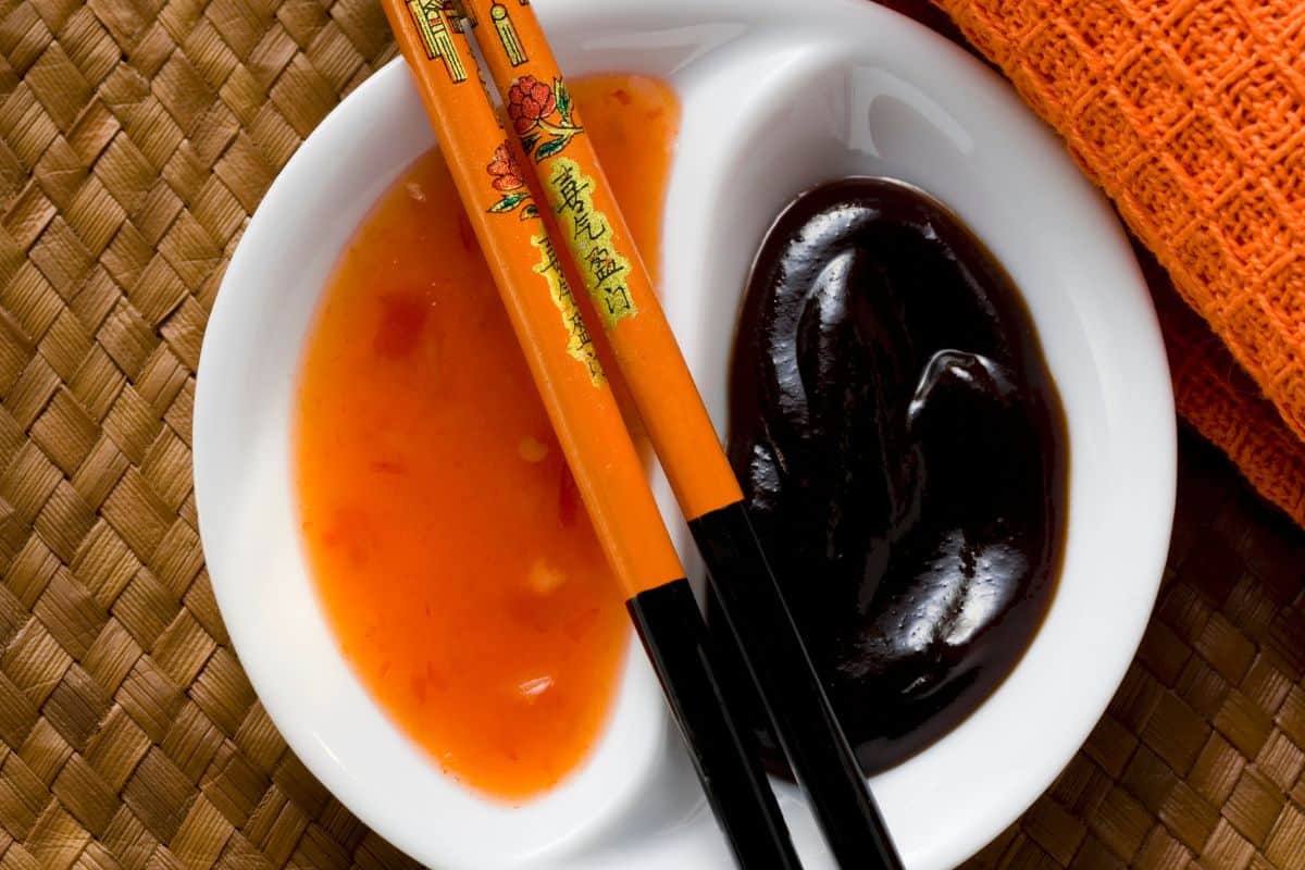 A sauce bowl of hoisin sauce with a side of sweet chili sauce.