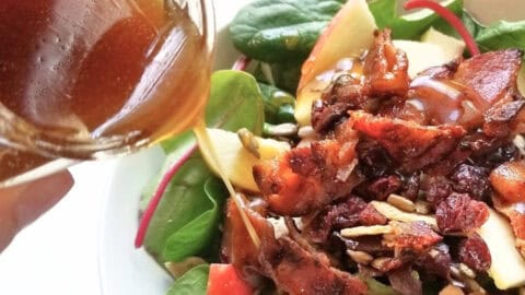 A plate of salad, topped with honey balsamic dressing.