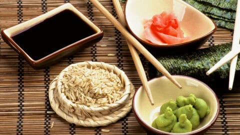 Various bowls with sushi set, including wasabi, raw sushi, and a dipping sauce.