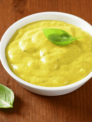 A bowl of curry sauce, topped with fresh leaf.