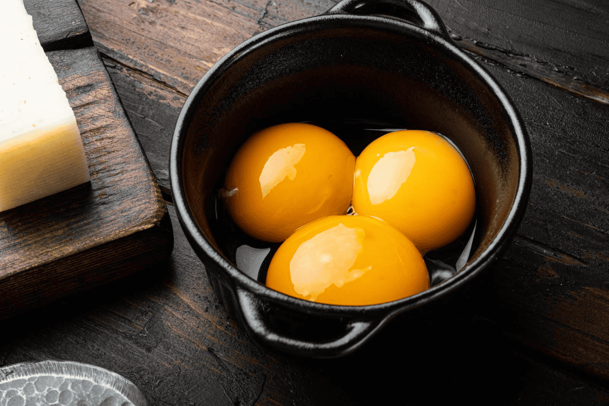 Three egg yolks in a bowl.