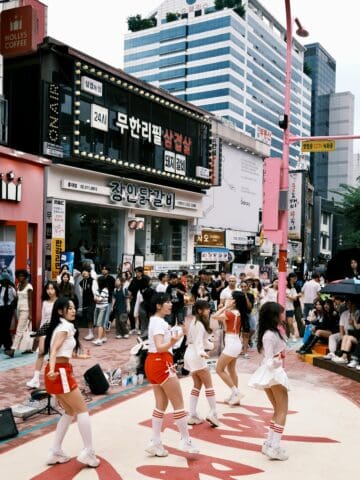 Vibrant street scene in Seoul Korea with dancers performing in busy city center.