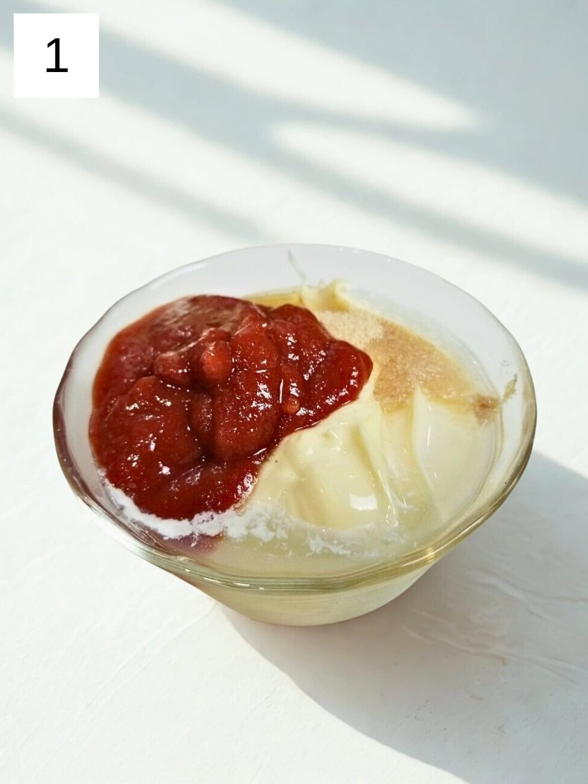 A mixture of sriracha mayo ingredients in a glass bowl.