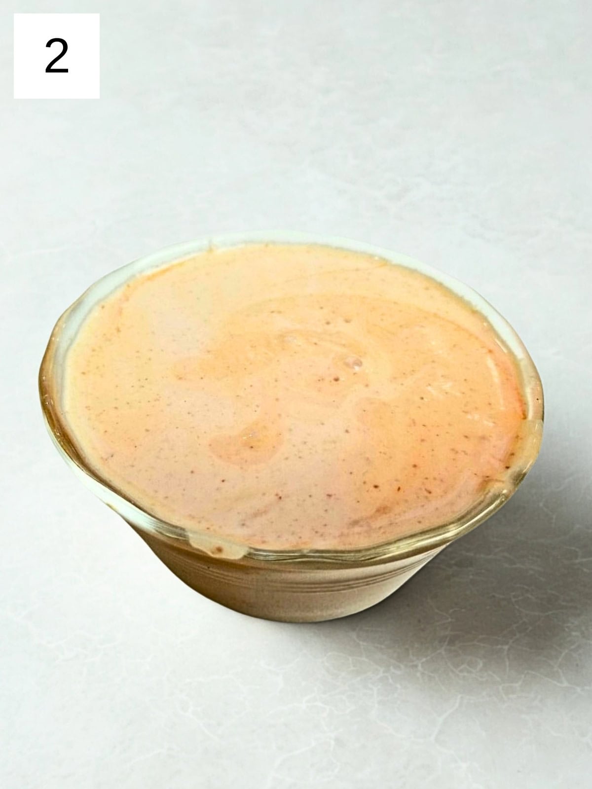 A mixture of sriracha mayo dip in a glass bowl.
