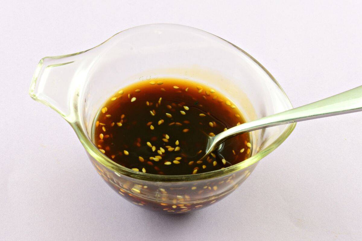 A glass sauce bowl of teriyaki sauce.