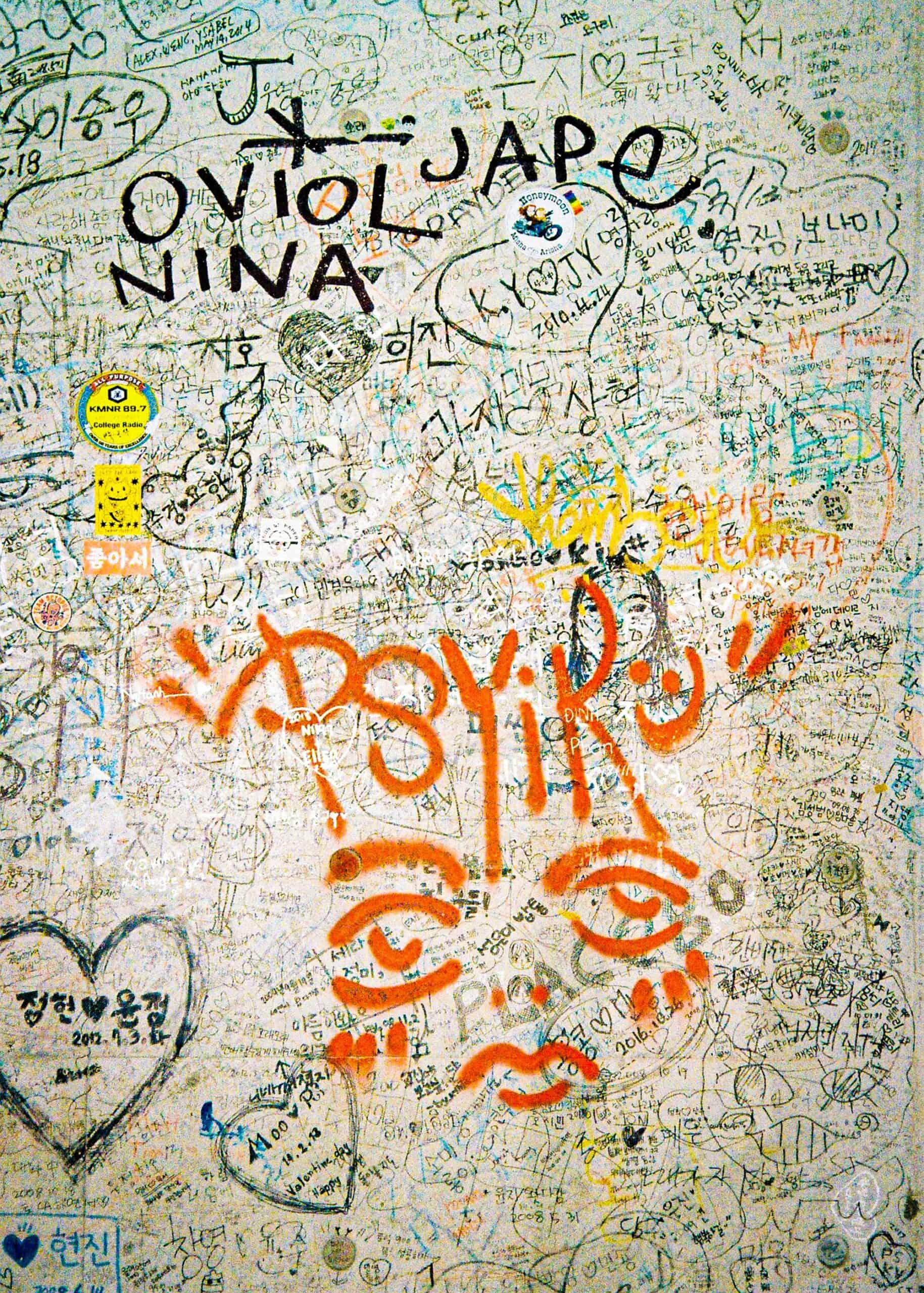 Colorful graffiti and handwritten messages on a wall create a lively Seoul Korea Asia scene.