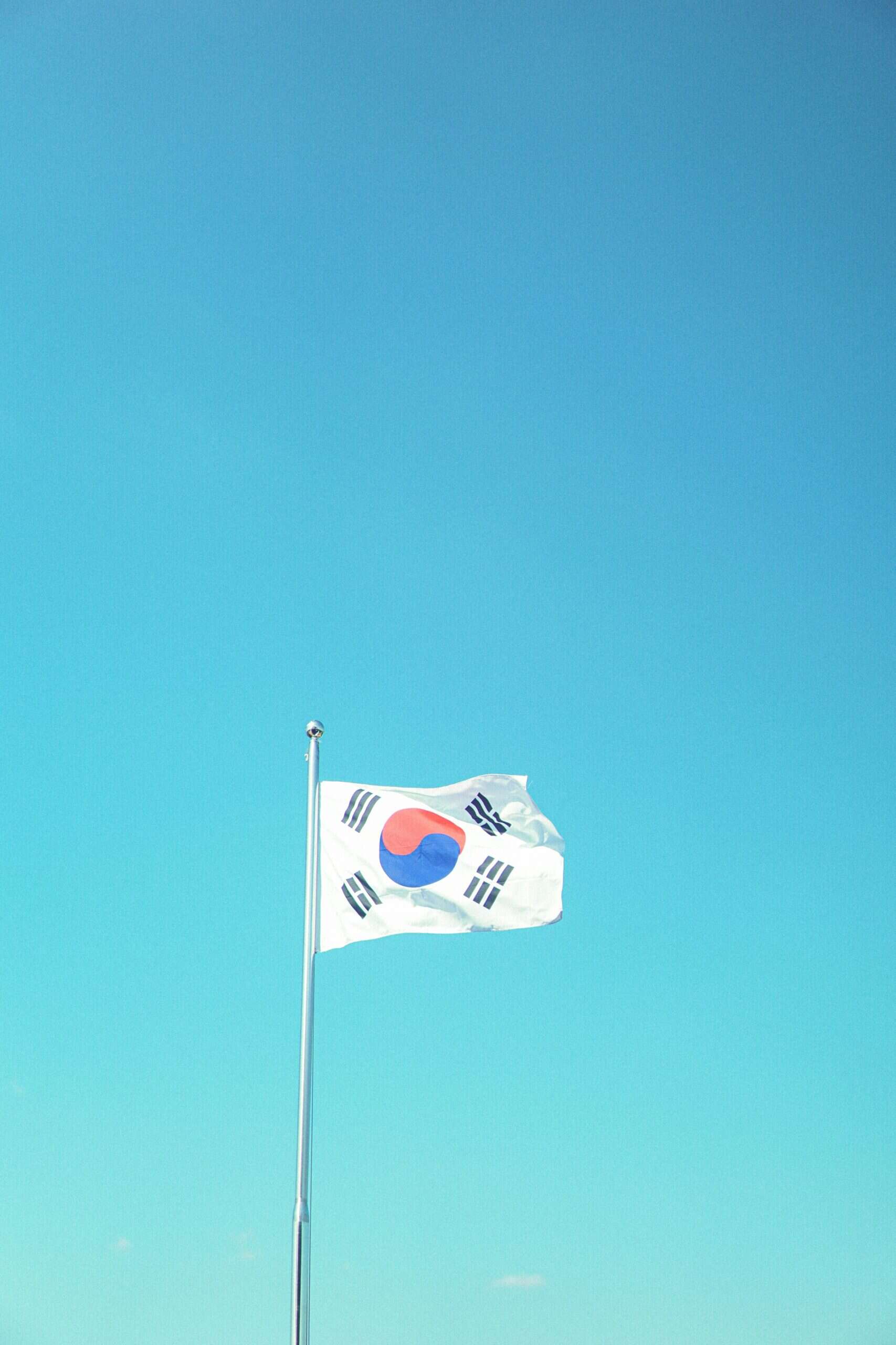 Korean national flag flying against clear blue sky, representing Seoul Korea Asia.