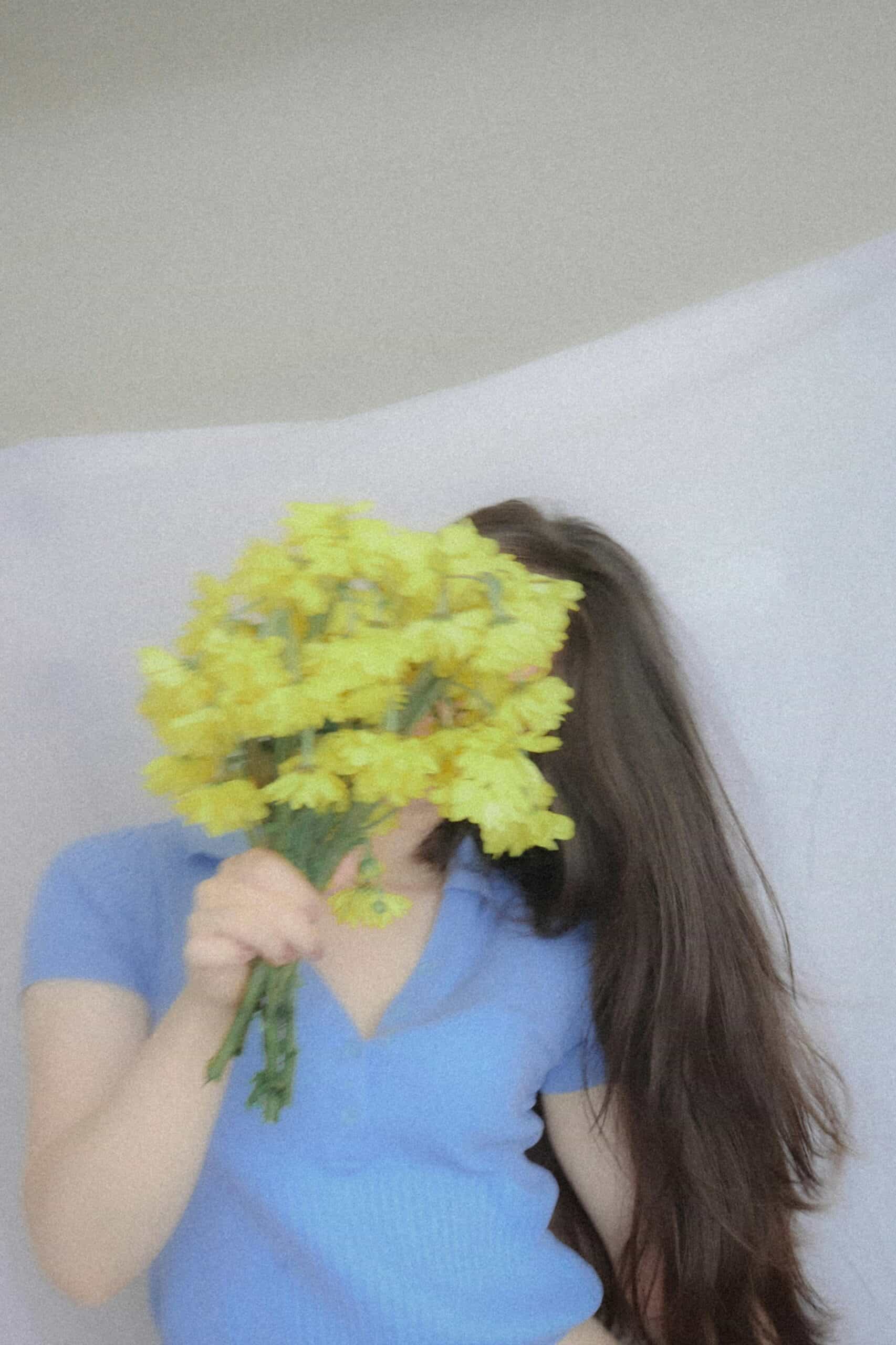 Bright yellow flower bouquet covering face, casual fashion, Seoul lifestyle vibe.