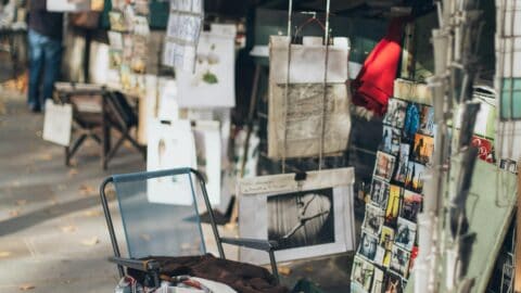 Vintage outdoor market stall in Seoul, Korea, selling books, artwork, and souvenirs with a small dog.