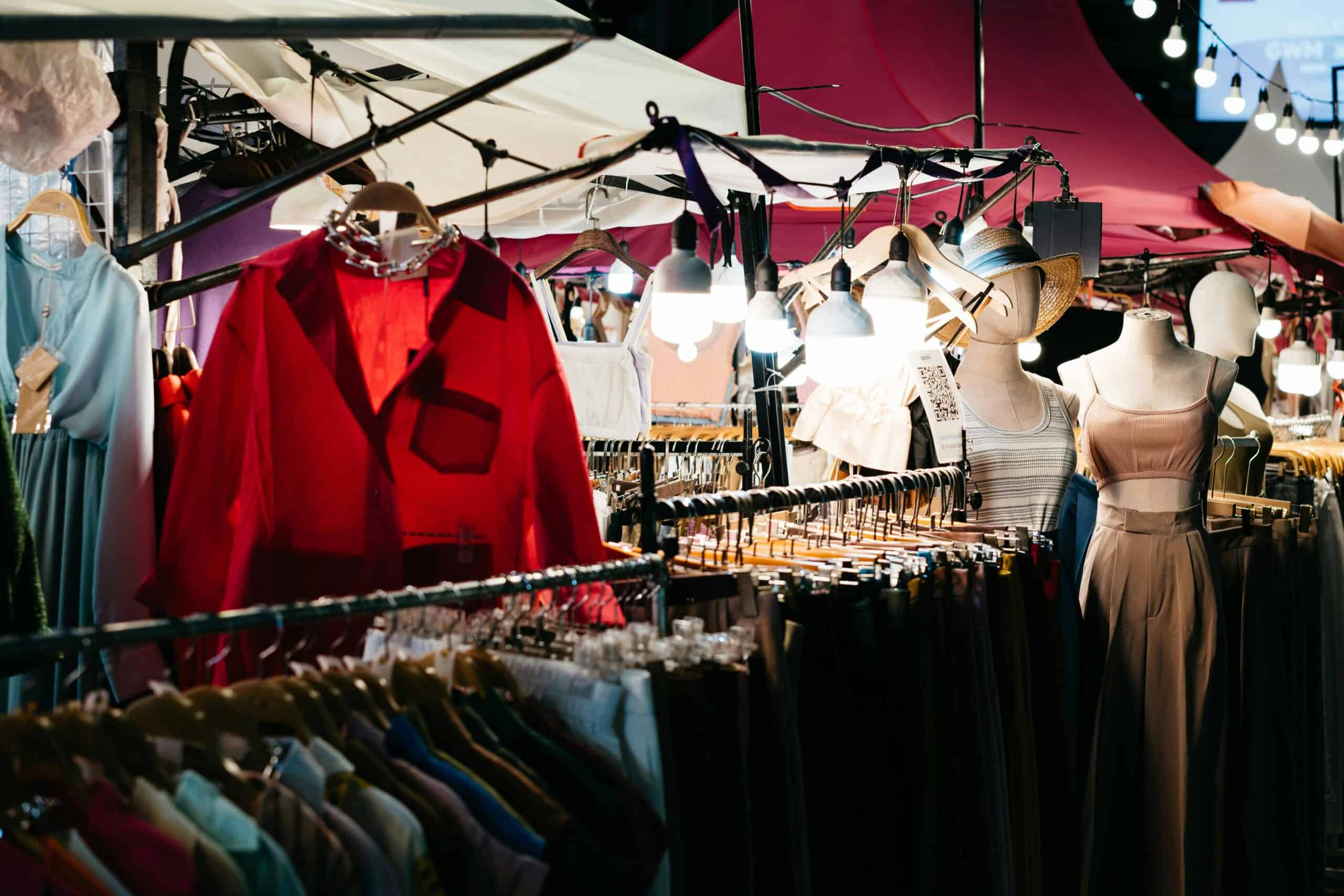 Outdoor vintage clothing market in Seoul with racks of colorful apparel and mannequins.