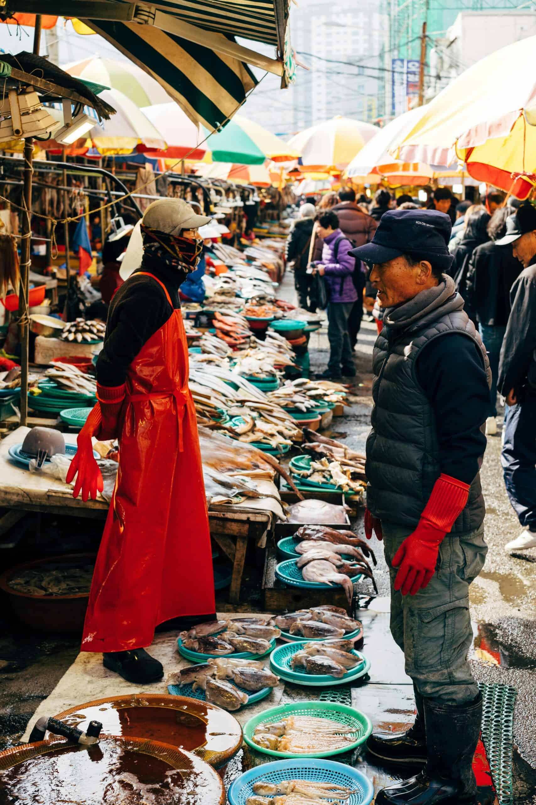Seafood market in Seoul with fresh fish and shellfish displays.