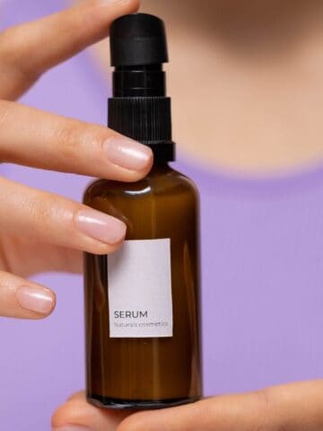 Amber glass serum bottle held in both hands